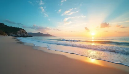 Fotobehang Zonsondergang Golden sun sets over calm ocean beach with soft light. Gentle waves roll onto vast sand shore. Coastal mountains, green hills meet blue sea. Sky soft clouds. Tropical nature scene peaceful, great for  © Maryna