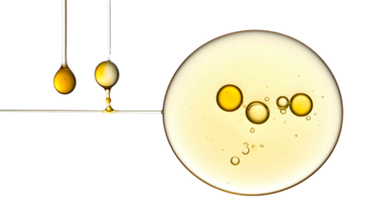 Macro shot of oil droplets and a large circular pool with bubbles, against a black backdrop