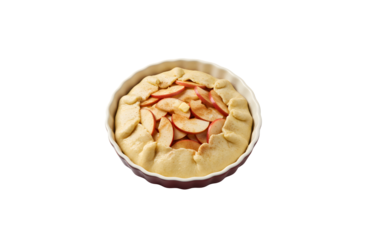 A baking dish filled with fresh dough and apples, set against a white background. Preparing a galette.

