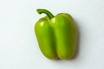 A single vibrant green bell pepper on a white background