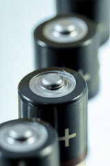 Close up of a row of aa batteries on a white background