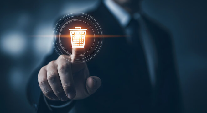Businessman's finger pointing at a digital trash can icon, representing data deletion and information management in the digital era.