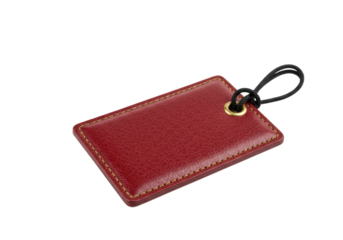 Isolated red leather luggage tag with black loop on bright neutral surface for travel, bag