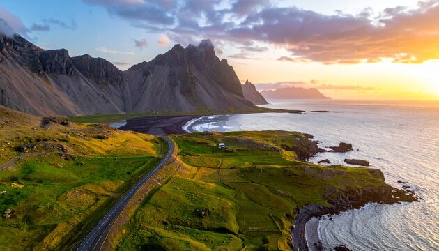 Generated imagA dramatic coastal landscape with a winding road leading to jagged mountains, bordered by a black sand beach and lush green fields under a vibrant sunset sky.