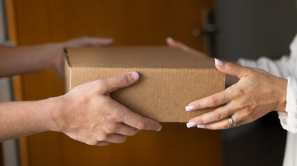 Close up cropped shot man woman hands holding cardboard box