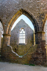 The abbey of Saint-Mathieu de Fine-Terre in Brittany, France.  Ancient gothic ruin interior with arched vaults, stone columns, and open courtyard view