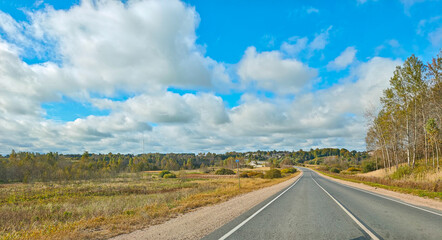 Country road through fields and forest cloudy day freedom of the road horizontal frame