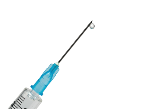 Isolated syringe with needle and drop of clear medicine in front of a plain backdrop