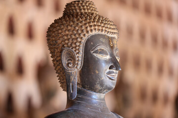 Golden ancient Buddha statue in a Lao temple with a serene meditation face, an iconic religious Asian sculpture representing peace and spirituality, Vientiane, Laos