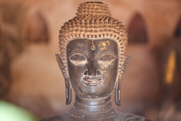 Golden ancient Buddha statue in a Lao temple with a serene meditation face, an iconic religious Asian sculpture representing peace and spirituality, Vientiane, Laos