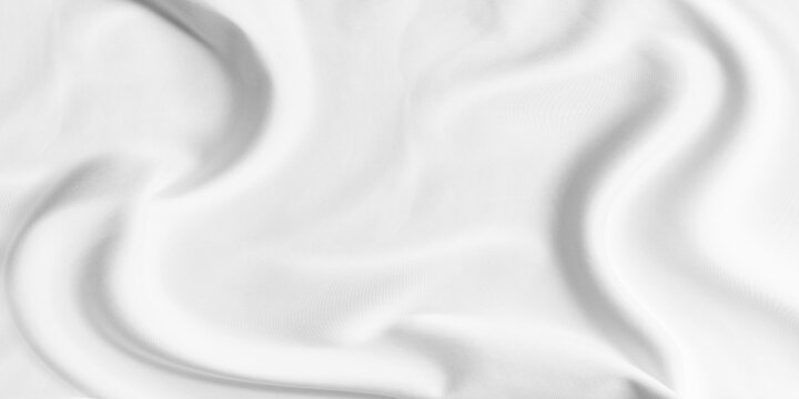 Beautifully high-key capturing soft flowing texture white fabric. Material draped and wrinkled creating gentle undulating waves and deep smooth curves contrast with faint woven pattern textile
