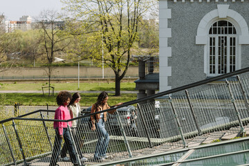 A woman walks up the stairs while two female friends walk behind her while they laugh
