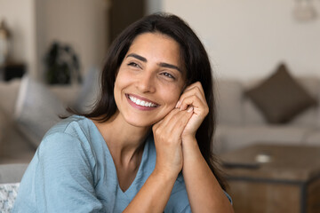 Joyful young Latin woman posing at cozy home