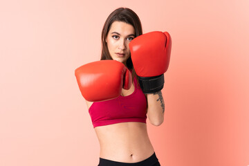 Young sport woman over isolated pink background with boxing gloves