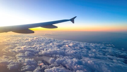 Fototapeta premium Airplane Wing Above Clouds at Sunrise