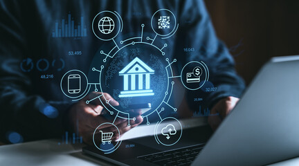 Digital banking hologram concept with icons of financial technology and online payment around smartphone and laptop on dark blurred background.