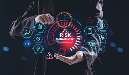 Businessman analyzing risk management concept with digital hologram interface and futuristic icons on dark background for financial data analysis..