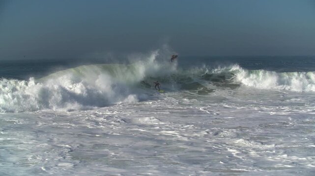 Surfers on giant shorebreak waves at The Wedge