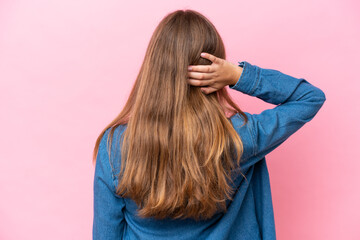 Fototapeta premium Young caucasian woman isolated on pink background in back position and thinking