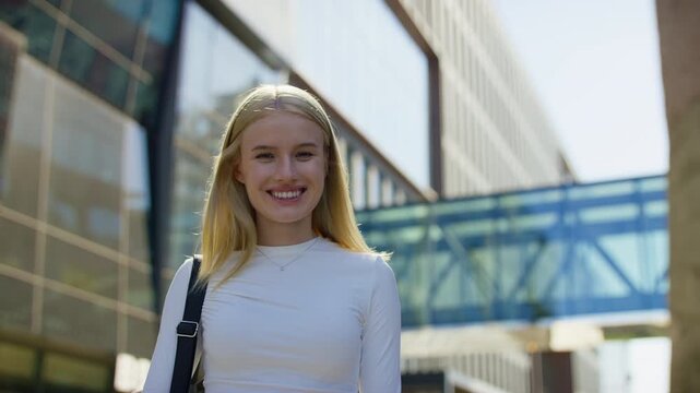 Confident woman turning and smiling at camera outdoors