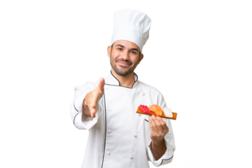 Young caucasian chef holding a sushi over isolated background shaking hands for closing a good deal