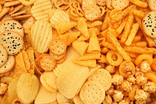 Colorful mix of salty snacks for beer varieties: chips and pretzels, rings and crackers. Non-healthy junk food background
