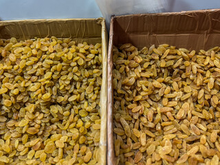 Different types of yellow and golden raisins in cardboard box 