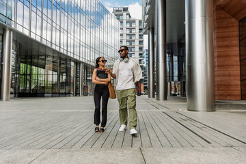 Obraz premium Male and female employees walk and carry folders while he talks