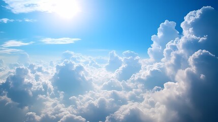 Expansive view of fluffy clouds illuminated by sunlight against a clear blue sky, evoking tranquility