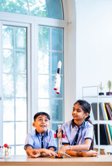 Indian students explore space rocket model in classroom while learning aerospace concepts in uniform