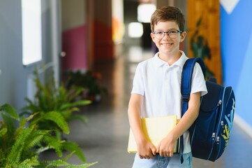 Portrait confident schoolboy in school corridor