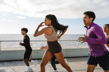 A group of five athletes look ahead while jogging