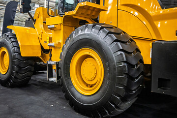Close-up of a powerful yellow heavy-duty wheel loader with large, rugged tires. Ideal for construction, excavation, and industrial themes, showcasing modern machinery and engineering.