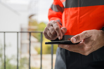 Closeup of hands of civil engineer using smartphone