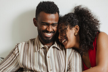 Obraz premium A woman rests her head on a man's shoulder and they laugh