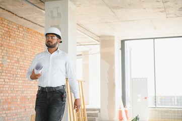 Fototapeta premium Construction concept. Portrait of a young architect at a construction site