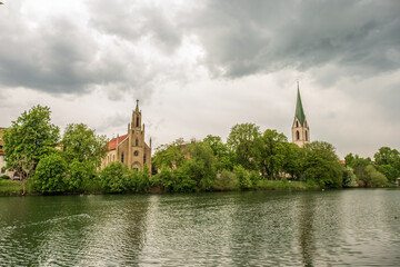 Evangelische Kirche und Stiftskirche St. Moritz am Neckarufer in Rottenburg vor Gewitterwolken