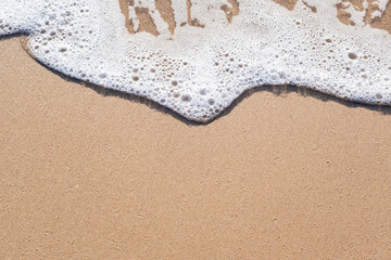 Sea foam on the shore with space for text