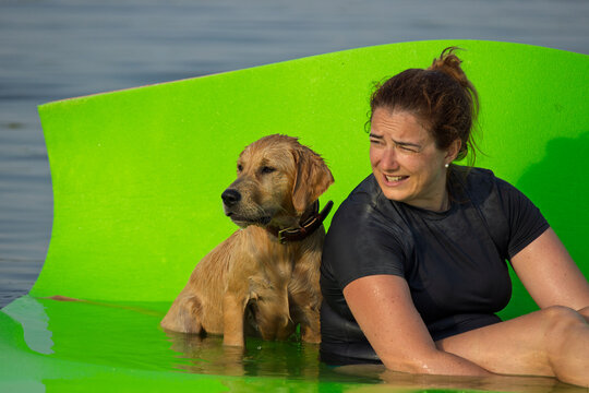 Woman and her dog sitting on a floating raft