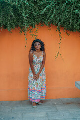 Fototapeta premium A woman in a floral dress is standing in front of a wall