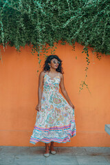 Fototapeta premium A woman in a white dress is standing in front of a green wall