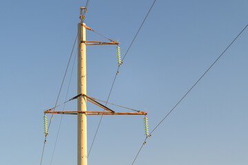 High voltage power lines stretch under a clear blue sky, connecting energy sectors
