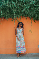 Fototapeta premium A woman in a white dress stands in front of a green wall