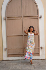 Fototapeta premium A woman in a white dress stands in front of a brown door