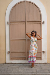 Fototapeta premium A woman in a white dress stands in front of a brown door