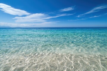 A tranquil view of crystal clear turquoise waters and sandy beach under a bright blue sky