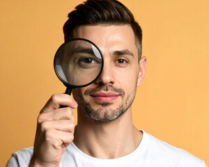 man looking through magnifying glass