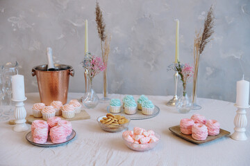 Full view of an elegant dessert table setup with pink and mint sweets, cookies, a copper champagne...