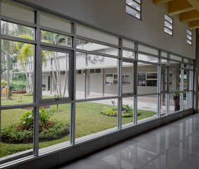 Modern Building Corridor with Large Glass Windows Overlooking Green Courtyard