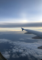 Vertical View from Airplane Window of Wing and Clouds at High Altitude